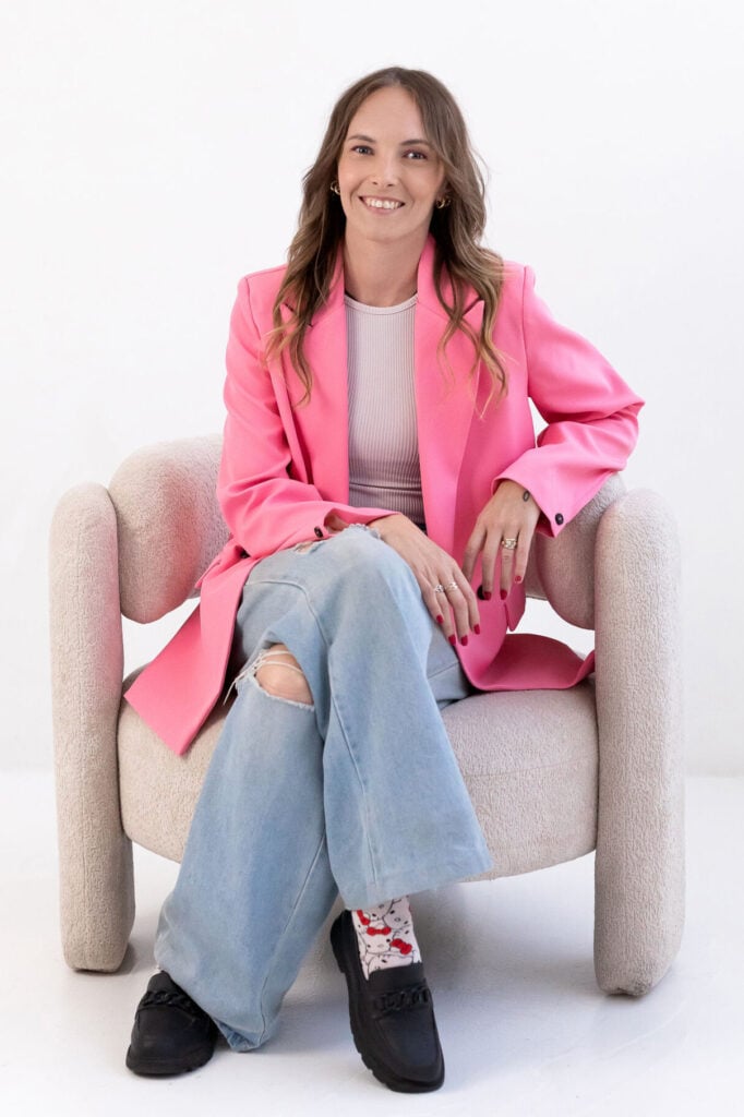 Hot Shot Events team member in a pink blazer seated in an armchair